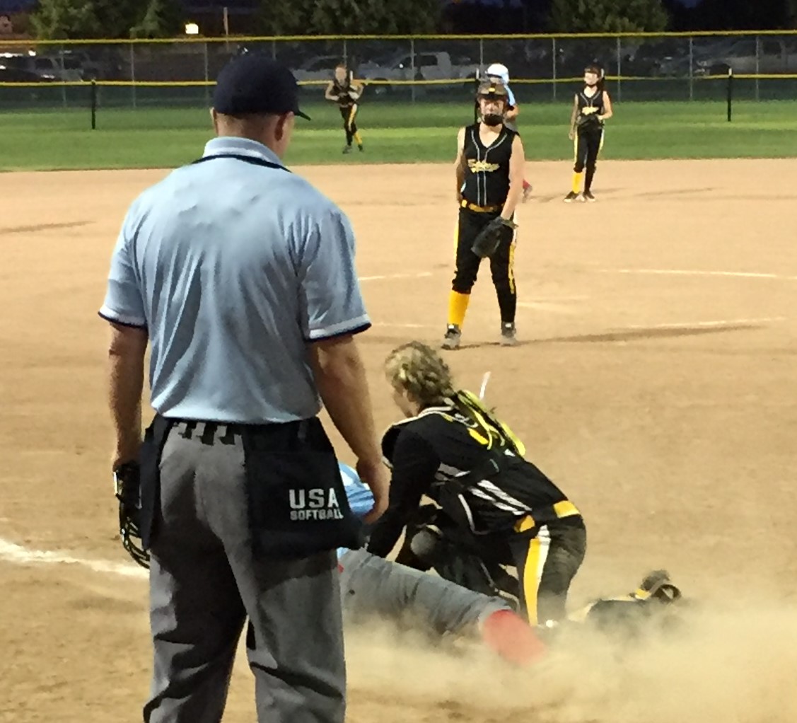 Play at the plate during Girls' Accelerated Softball game