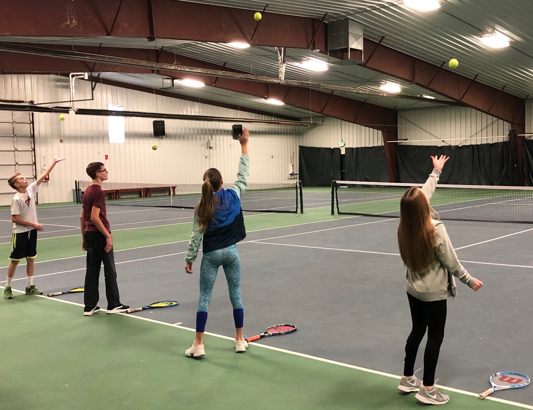 kids working on their tennis serves