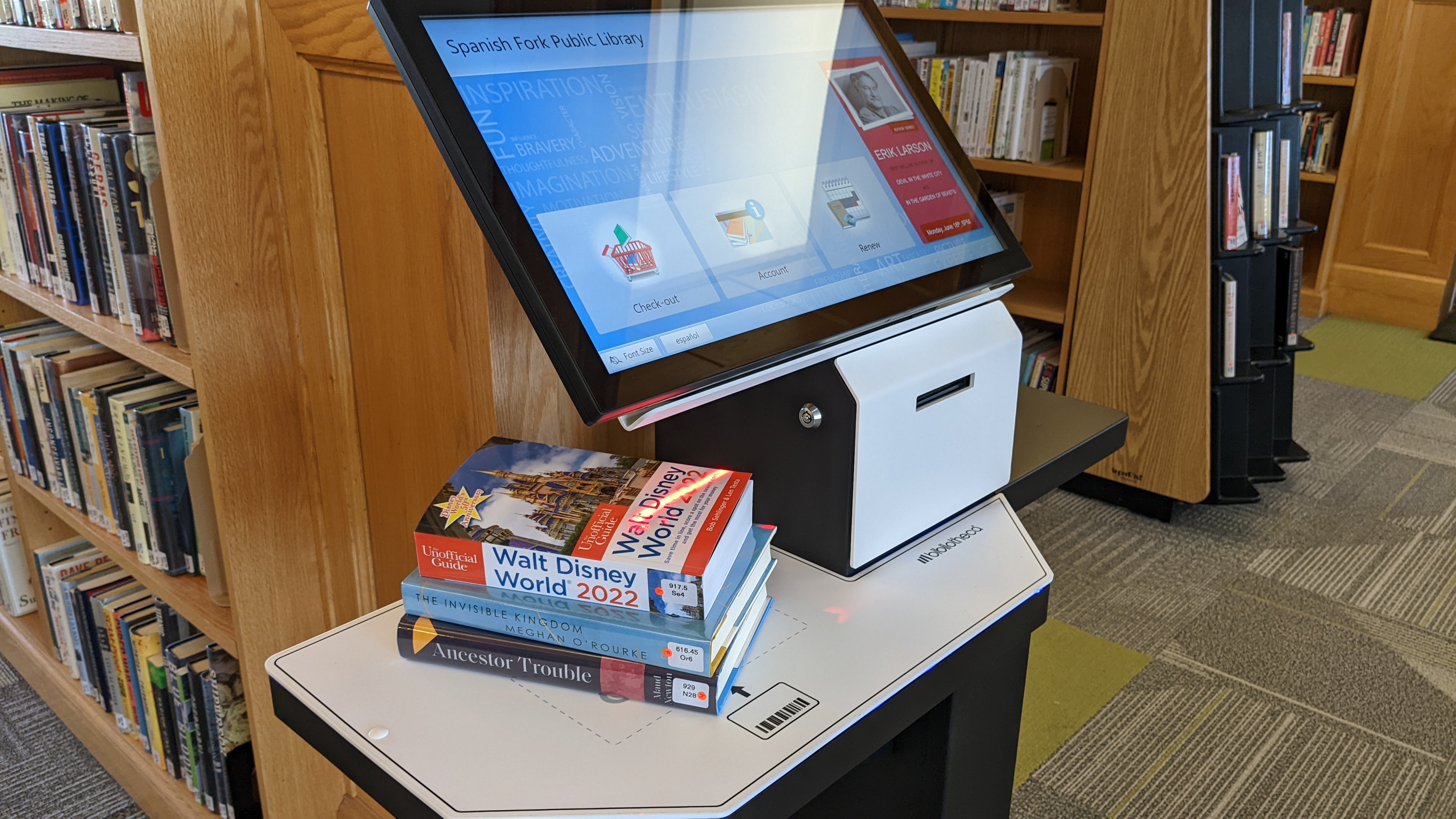 3 books stacked on a self-checkout kiosk.